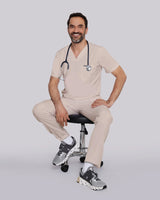 Junger moderner Arzt in stylischer Arbeitskleidung in beige