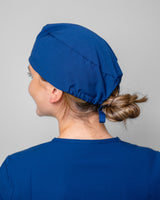 Junge Ärztin trägt moderne OP Haube in leuchtendem Royalblau