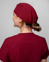 Junge Ärztin mit kräftig bordeauxfarbener OP Haube in Burgundy