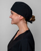 Schwarze OP Haube sitzt perfekt auf dem Kopf der jungen Medizinerin