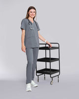 Junge Ärztin in medizinischer Berufsbekleidung in grau lächelt in die Kamera