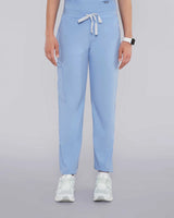 Junge Ärztin in Sneakern und moderner medizinischer Damenhose in hellblau