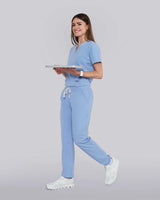 Junge Ärztin in medizinischer Berufsbekleidung in hellblau lächelt in die Kamera