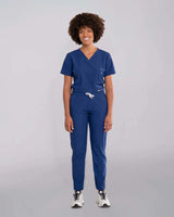 Junge Ärztin in Sneakern und moderner medizinischer Damenhose in blau