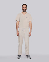 Junger Mediziner kombiniert Sneaker mit modernem Kasack un beiger Schlupfhose