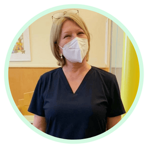 Zufriedene Ärztin trägt ihren neuen dunkelblauen Kasack von mjuks