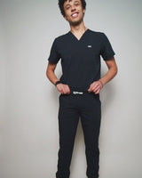 Junger Arzt in moderner und bequemer medizinischer Berufsbekleidung in dunkelblau