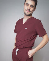 Junger Arzt in moderner und bequemer medizinischer Berufsbekleidung in dunkelrot