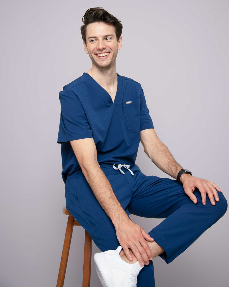 Junger Arzt in moderner und bequemer medizinischer Berufsbekleidung in blau