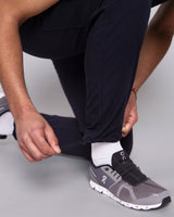 Arzt in dunkelblauer Herrenhose mit längenverstellbaren Gummizug am Hosenende