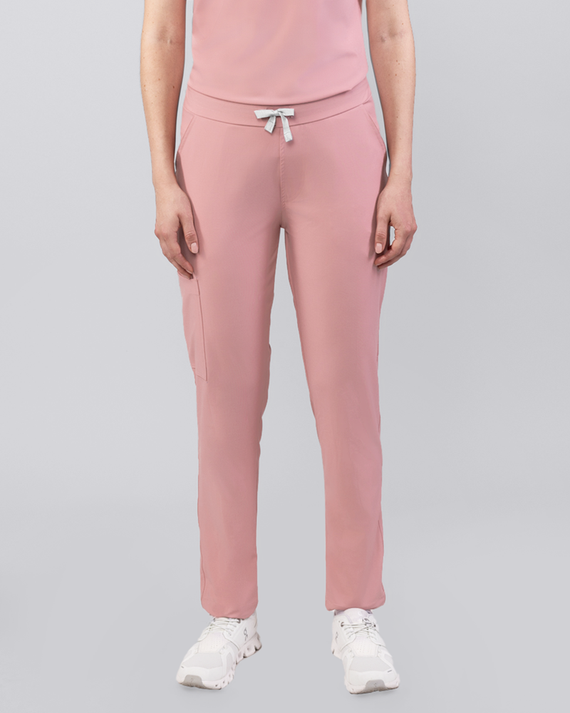Junge Medizinerin in moderner rosa medizinischer Damenhose