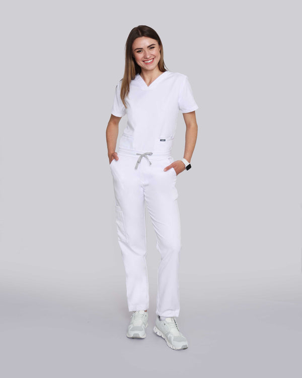 Junge Ärztin in Sneakern und moderner medizinischer Damenhose in weiß