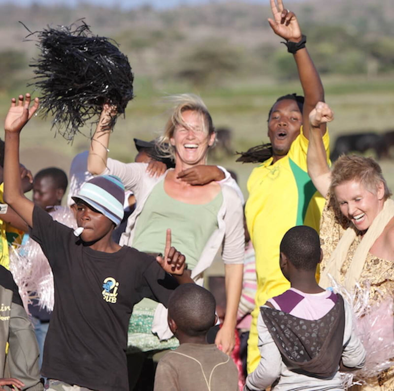 2 Ärtzinnen lachen und tanzen mit Schulkindern in Afrika