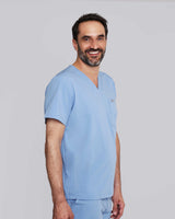 Junger Arzt in modernem und bequemem Kasack in hellblau mit praktischer Fronttasche und V-Ausschnitt