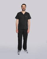 Junger Arzt in Sneakern mit Apple Watch und moderner Praxiskleidung in schwarz