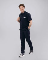 Junger Arzt mit dunkelblauem medizinischem Poloshirt und elegantem Kragen