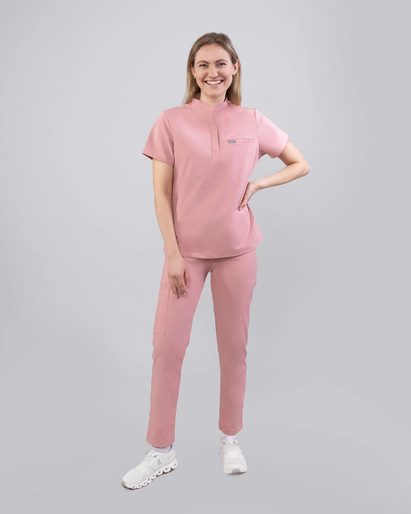 Ärztin in bequemer medizinischer Arbeitskleidung mit Stechkragen in Rosa