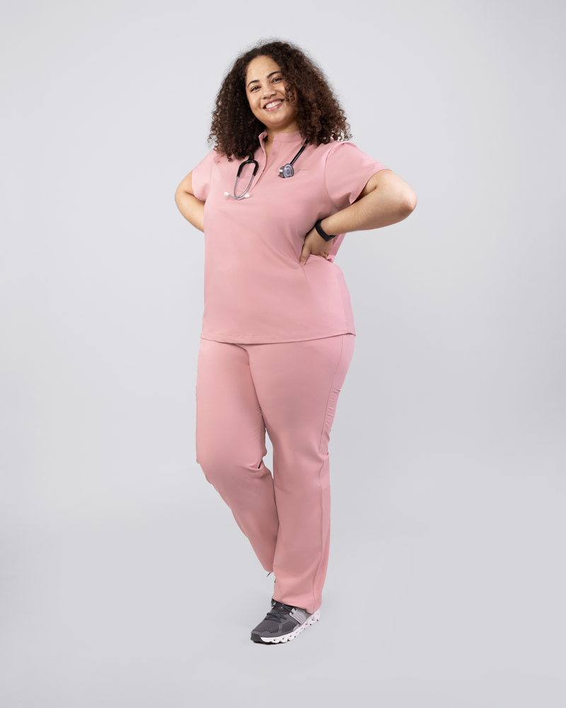Medizinerin in stilvollem Kasack mit Stehkragen in Rosa und Sneakern