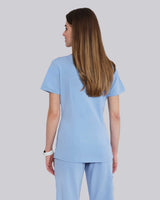 Junge Medizinerin in weißen Sneakern und moderner Arbeitsbekleidung in hellblau