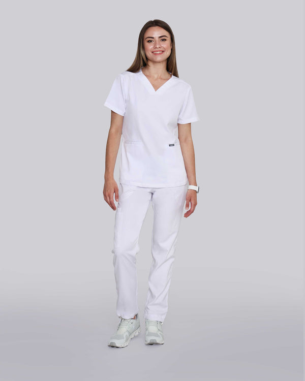 Junge Medizinerin in weißen Sneakern und moderner Arbeitsbekleidung in weiß