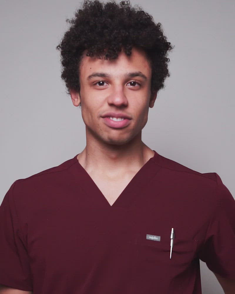 Junger Arzt in moderner und bequemer medizinischer Berufsbekleidung in dunkelrot