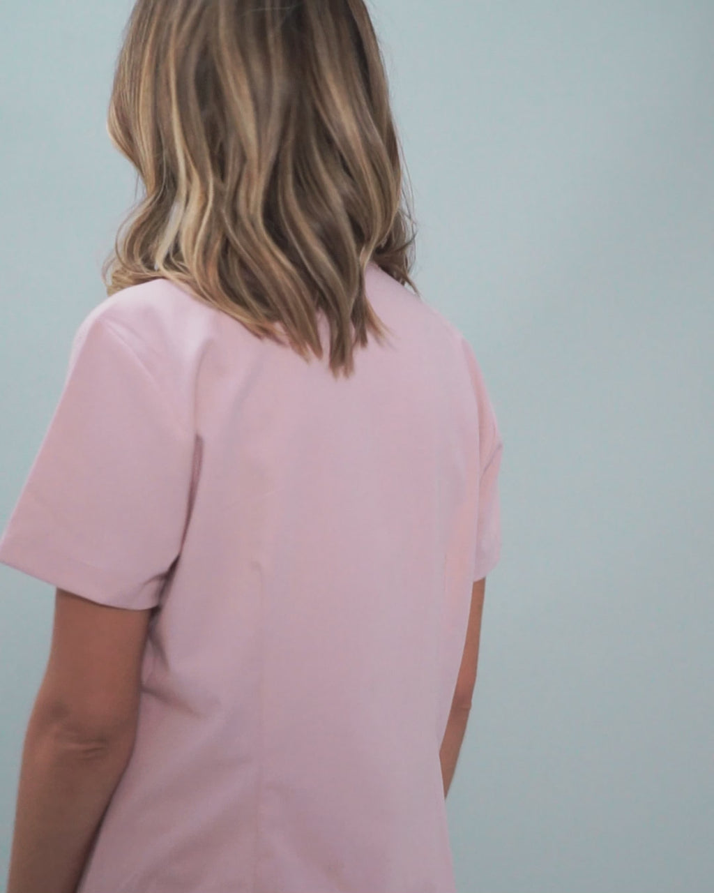 Junge Ärztin mit rosa medizinischer Berufsbekleidung im Detail
