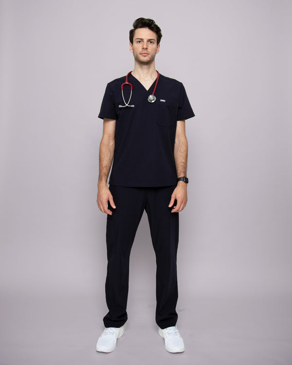 Junger Arzt in Sneakern mit Apple Watch und moderner Praxiskleidung in dunkelblau