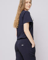 Junge Ärztin von hinten in ihrem modernen Damenkasack in dunkelblau