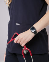 Junge Ärztin mit Appel Watch und Stethoskop in dunkelblauer Praxiskleidung