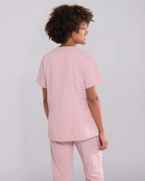 Junge Ärztin von hinten in rosa medizinischer Arbeitskleidung